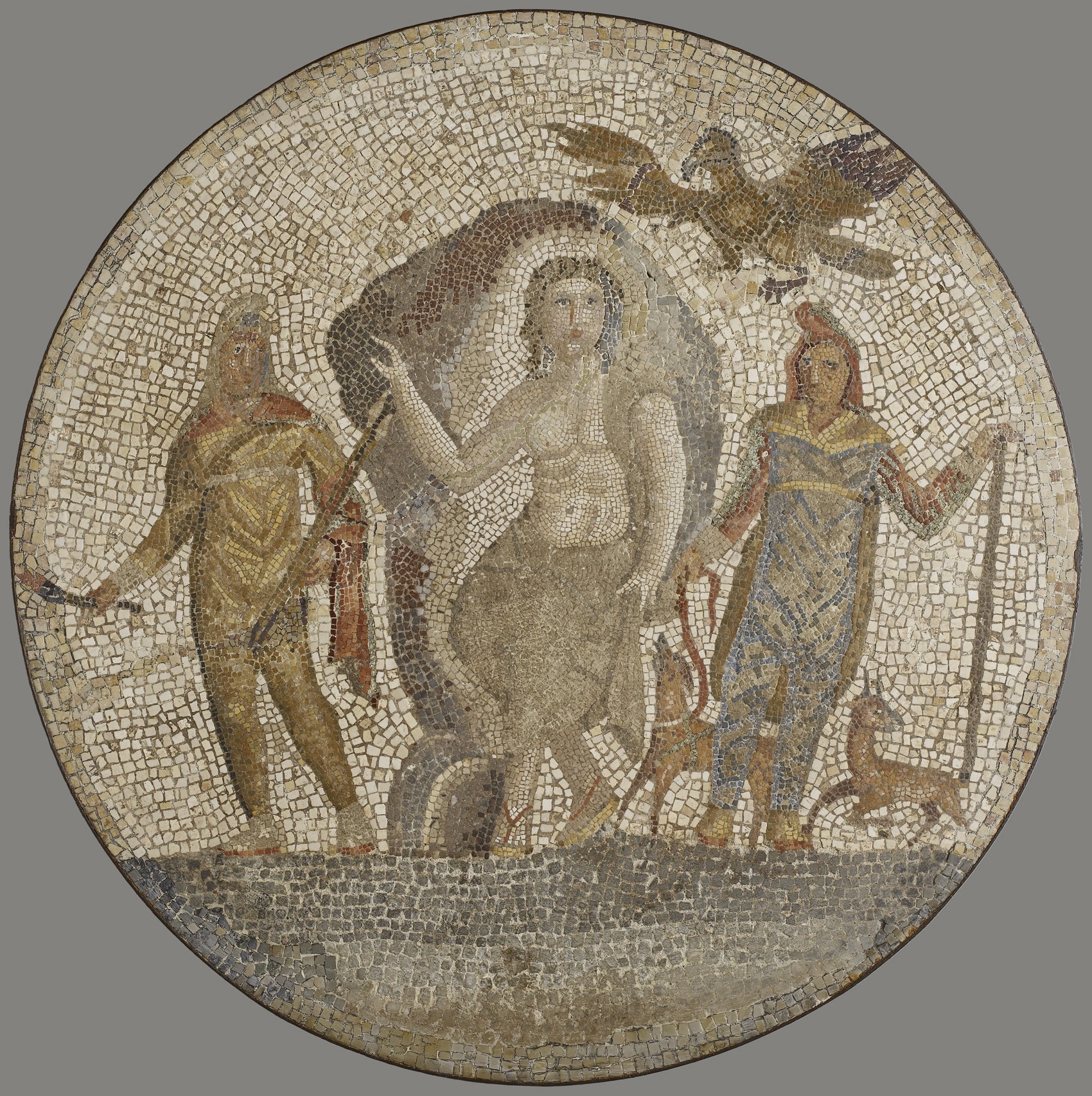 Uprostřed je bůh Mithra, vlevo Cautés (Světlo) a vpravo Cautopatés (Stín). Římská mozaika nalezená v Egyptě, 1. století. Převzato z http://art.thewalters.org. Mithra_rim._mozaika
